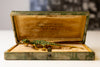 A green lizard brooch displayed in a box, previously owned by Fidel Castro's mistress.